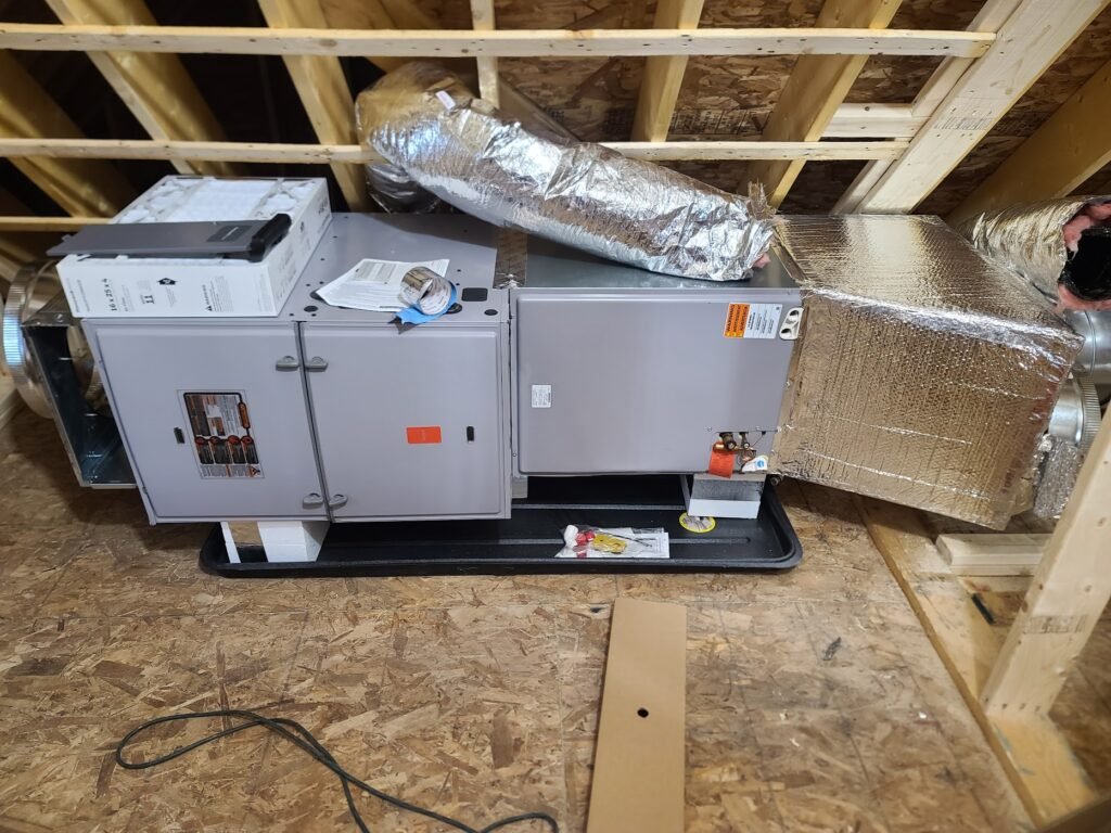 HVAC technician installing a high-efficiency furnace in a home in Nashua, NH